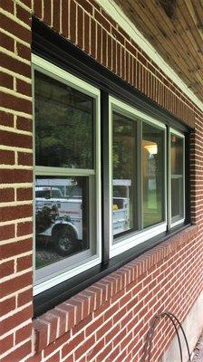 New double hung window installation with black aluminum capping.