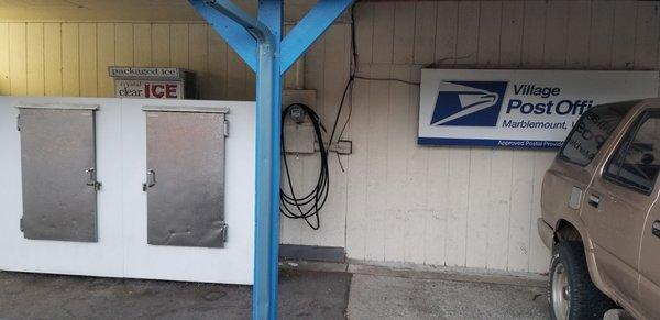 The air machine is inconspicuous between the ice freezers and the "Village Post Office" sign.