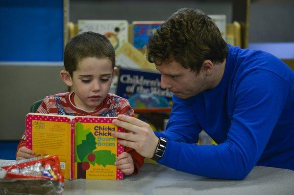 A Hopebridge therapists reading with a child.