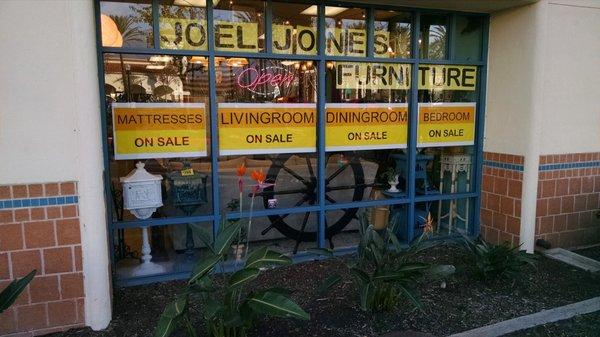 Side street window for Joel Jones Furniture across parking lot from Aldi and Office Max