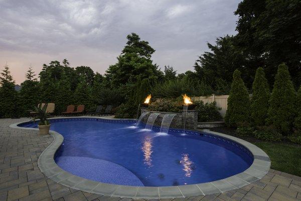 Vinyl-lined freeform pool with waterfall and fire features.