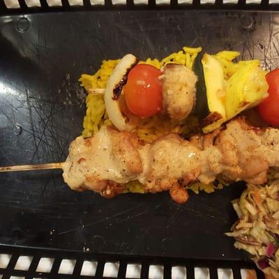 Middle Eastern chicken kabob and marinated veggie kabob served over golden rice