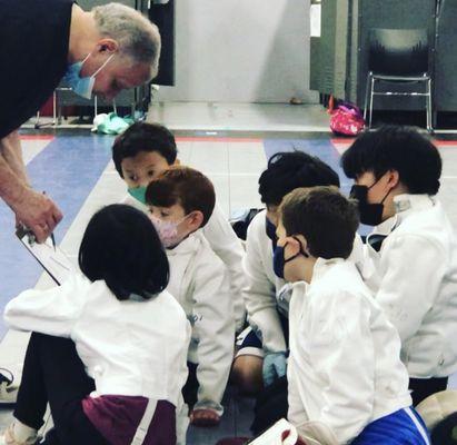 Beginner fencers at summer camp learn how the scoring works. Questions happily answered!