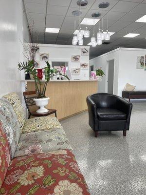 Waiting area with modern pendant lights and eyebrow pictures on wall