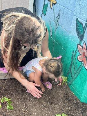 Gardening in the organic garden with her teacher.