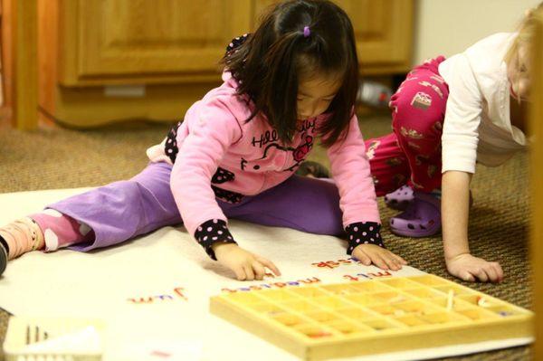 Primary child working with the moveable alphabet.