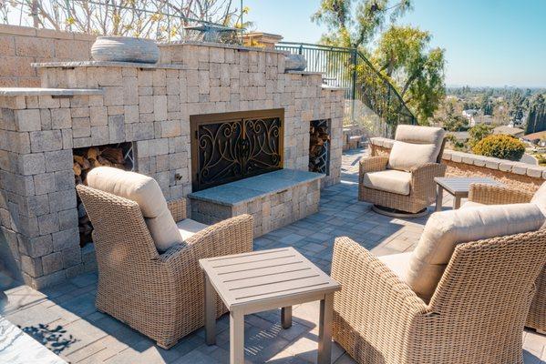 Custom fireplace with hearth and paver seating area.