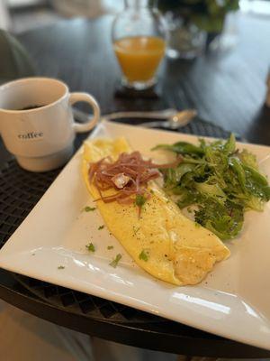 Omelette Suffle topped with prosciutto and a side salad