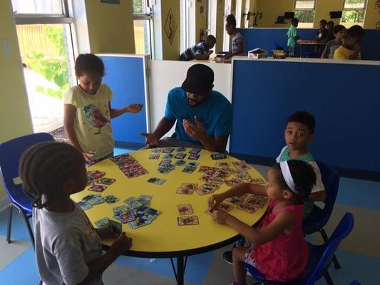 One of our after school program teachers and some students discussing trading cards.