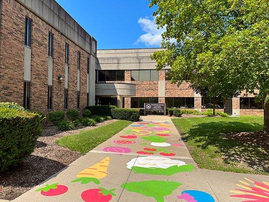 Follow the painted sidewalk to enter the building at 555 Towner St, Ypsilanti, MI