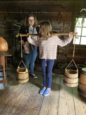 Demonstrating an eight year old child carrying heavy water to supply the household