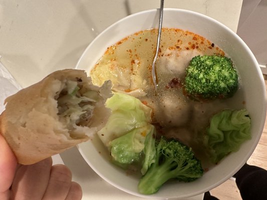 Close-up of wonton soup and egg roll