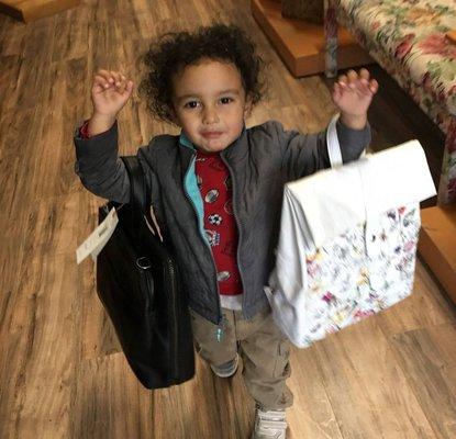 RJ with his favorite bags - the Doshi Debut Paper Backpack and the Cassidy in Black from Matt & Nat.