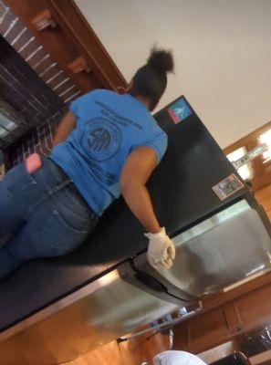 Sponge-Mob Cleaner cleaning around a refrigerator.