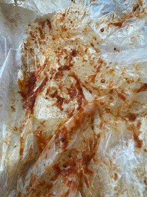 Wax paper wrapper drenched with sauce still, most was left wrapped around the sandwich