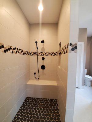 Master walk-in shower with a bench and niche for storing products. Nice and bright with a modern accent tile that makes you go '"oh wow".