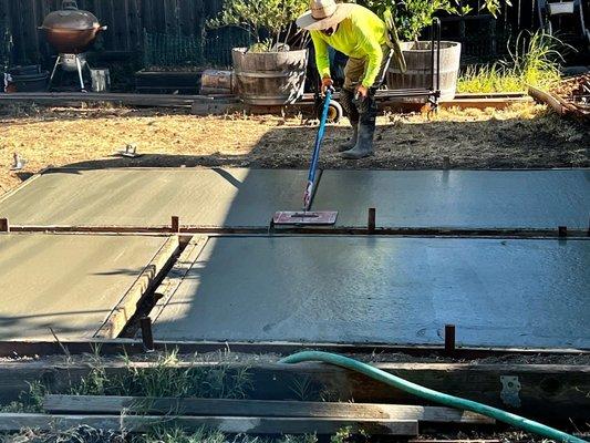 Crew member working on new backyard poured pavers