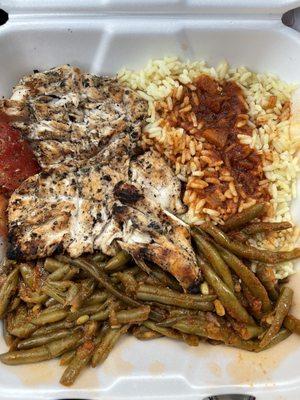 Chicken breast dinner with rice and green beans.