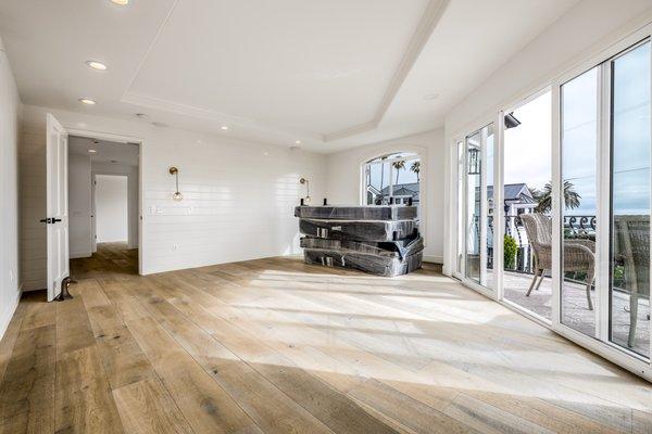 Primary bedroom featuring new flooring, lighting, and shiplap accent wall.