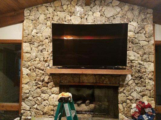 75 inch curve samsung over stone fireplace.