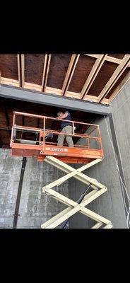 Pulling all CAT6 cables for cameras, access points and data with scissor lift.