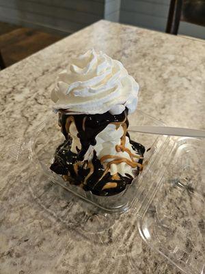 Krony's brownie sunday with vanilla icecream and topped with whipped cream, chocolate syrup, and peanut butter drizzle.