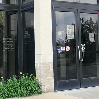 First Mid Bank & Trust St. Peters exterior building photo showing both lobby and drive-up hours on window.