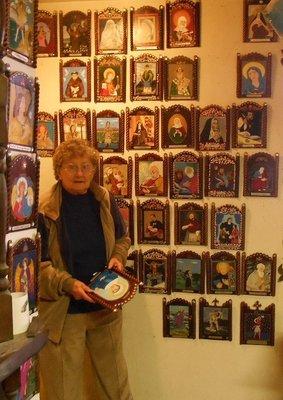 Patricia in studio with retablo art on wall.