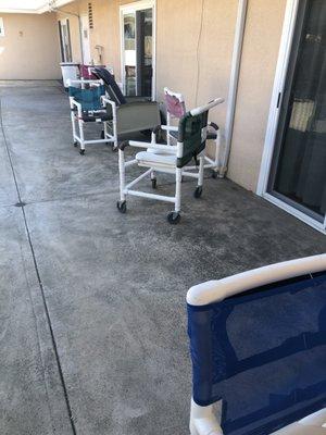 Shower chairs stored outside with bugs and spider webs