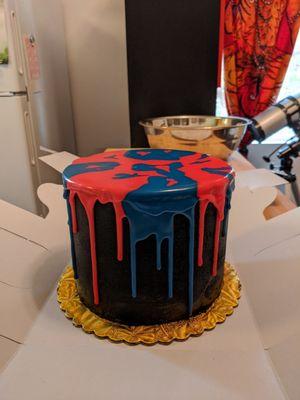 Red velvet cake with cream cheese layers; black buttercream with red/blue icing.