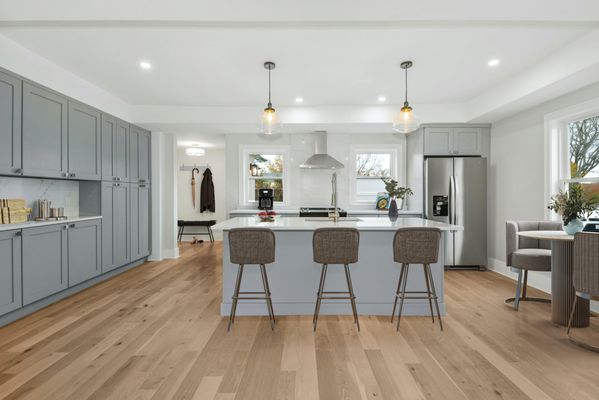 Kitchen remodel with gray cabinets, white quartz counters, and white oak floors