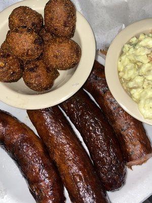 Pork hot links dinner with hush puppies and potato salad