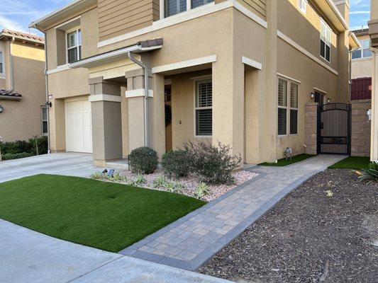 New paver walkway, CMU walls w/side gate, artificial turf, and rock infill at planter areas.