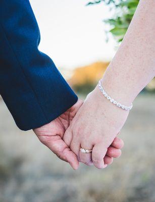 Hands clasped together during sunset photos