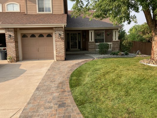 Newly installed pavers create a seamless driveway extension that also serves as a pathway leading up to the front porch. In Lone Tree CO