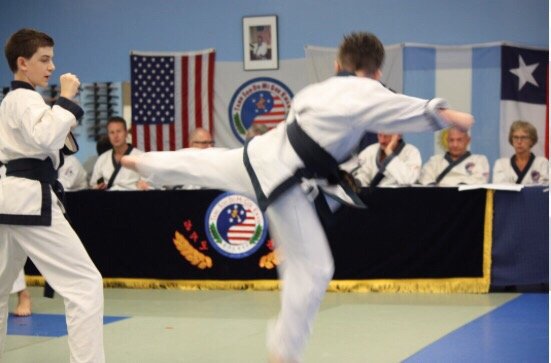 Jump spinning back kick to a partner.  Demonstrating focus and balance