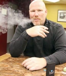 Steve Ryan exhales vegetable glycerin after puffing on an electronic cigarette. The vapor mist he exhales resembles the cloud of