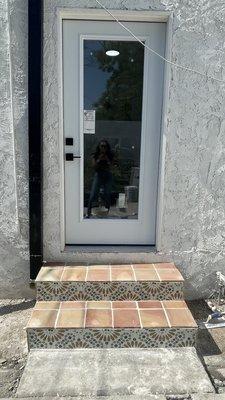 Additional work requested during initial bathroom project to add back door to back bedroom and two steps, including tile and stone coverage