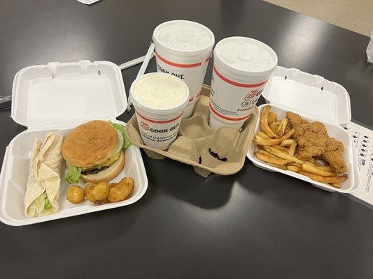 Burger and chicken tray with waters and a shake.