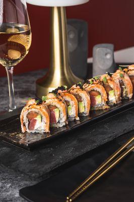 GENESISS ROLL - SALMON, TUNA, AVOCADO, CREAM CHEESE, TOPPED WITH FLAMED SALMON, YELOW PEPPER SAUCE, PASSION FRUIT AND TRUFFLE OIL.