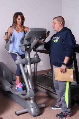 Trainer Mark helping Mona determine the optimum speed and resistance for her cardio interval.