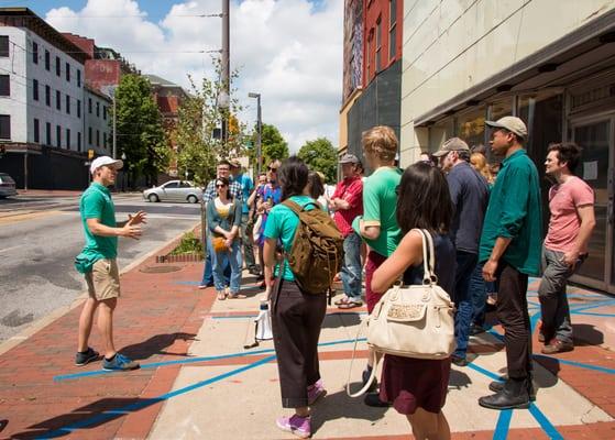 New Public Sites guide Graham Coreil-Allen kicking a tour along Howard Street in downtown Baltimore