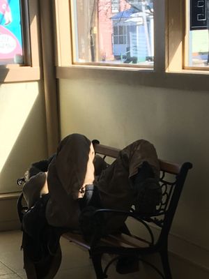 A very smelly person sleeping in the laundromat.