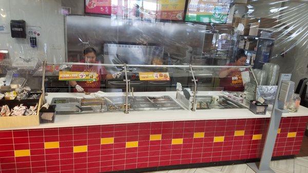 Plastic shields plus hanging plastic between customers and food (May 2021)