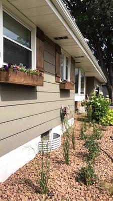 Completed window shutters and flower boxes, and landscaping