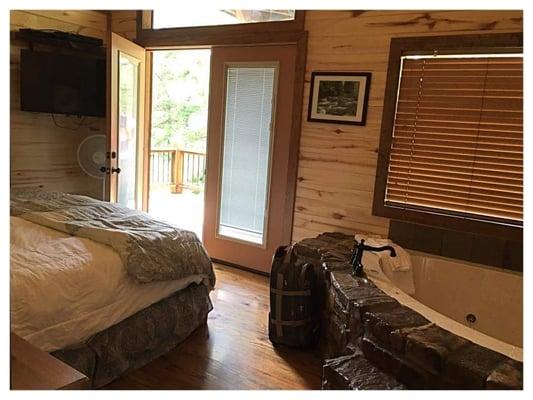 Antlers crossing bed with bath in room and both doors open