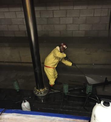 Pressure washing an elevator shaft that filled up with sewage, cleaned up and disinfected.