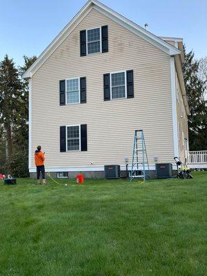 One of our employees pressure washing a house.