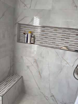 Sahara "Hibis" marble mosaic accents in shower niche and bench top.