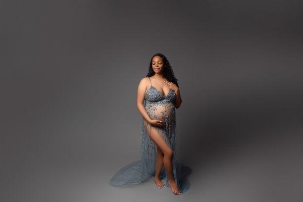 pregnant mama wearing a stunning hand beaded blue gown during her in-studio maternity session